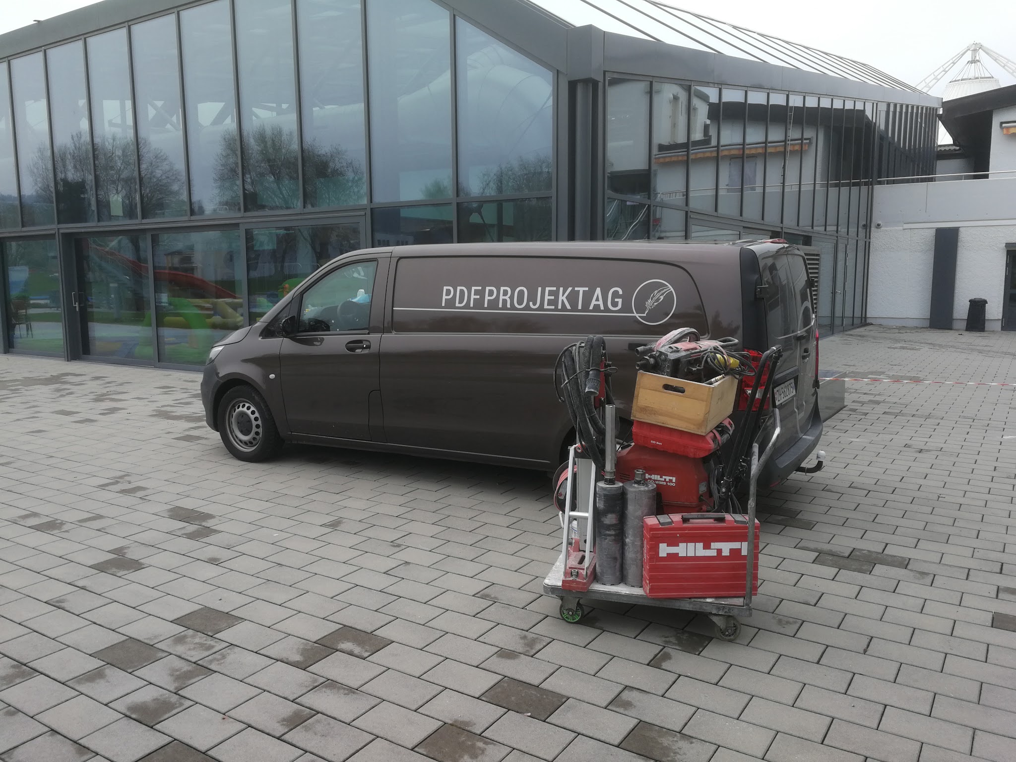 Firmenbus der PDF Projekt AG mit Hilti Bohrgerät auf einem Vorplatz