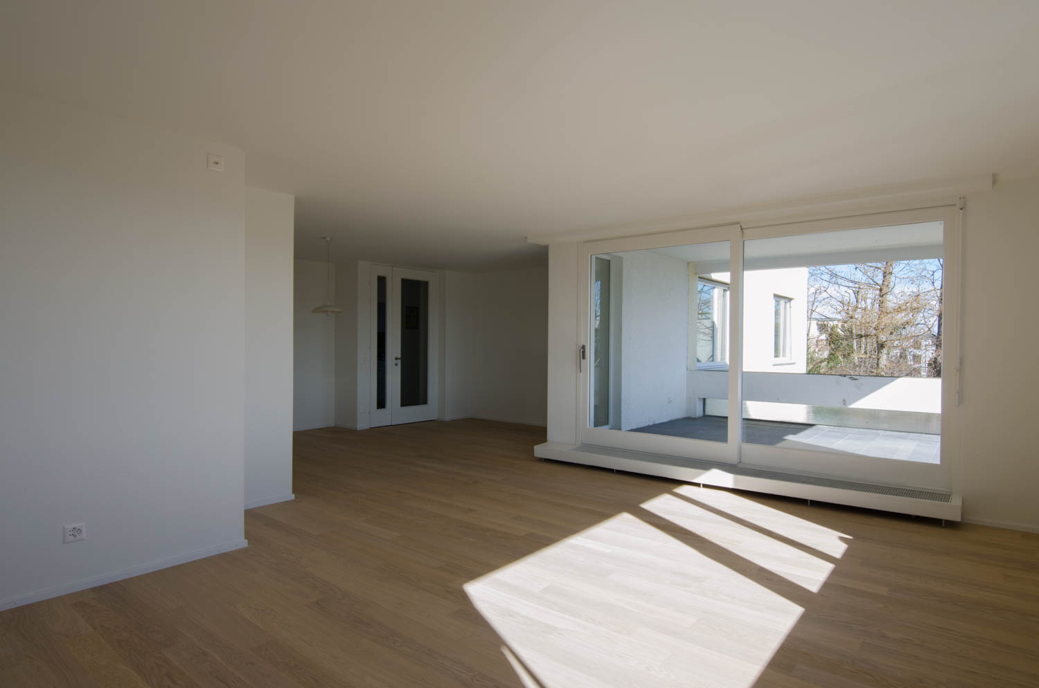 Heller Wohnraum mit Parkett und Terrassentür